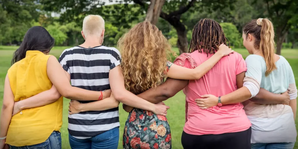 Image of the back of five friends holding each other.